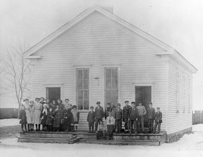 Two classes stand in front of the school.